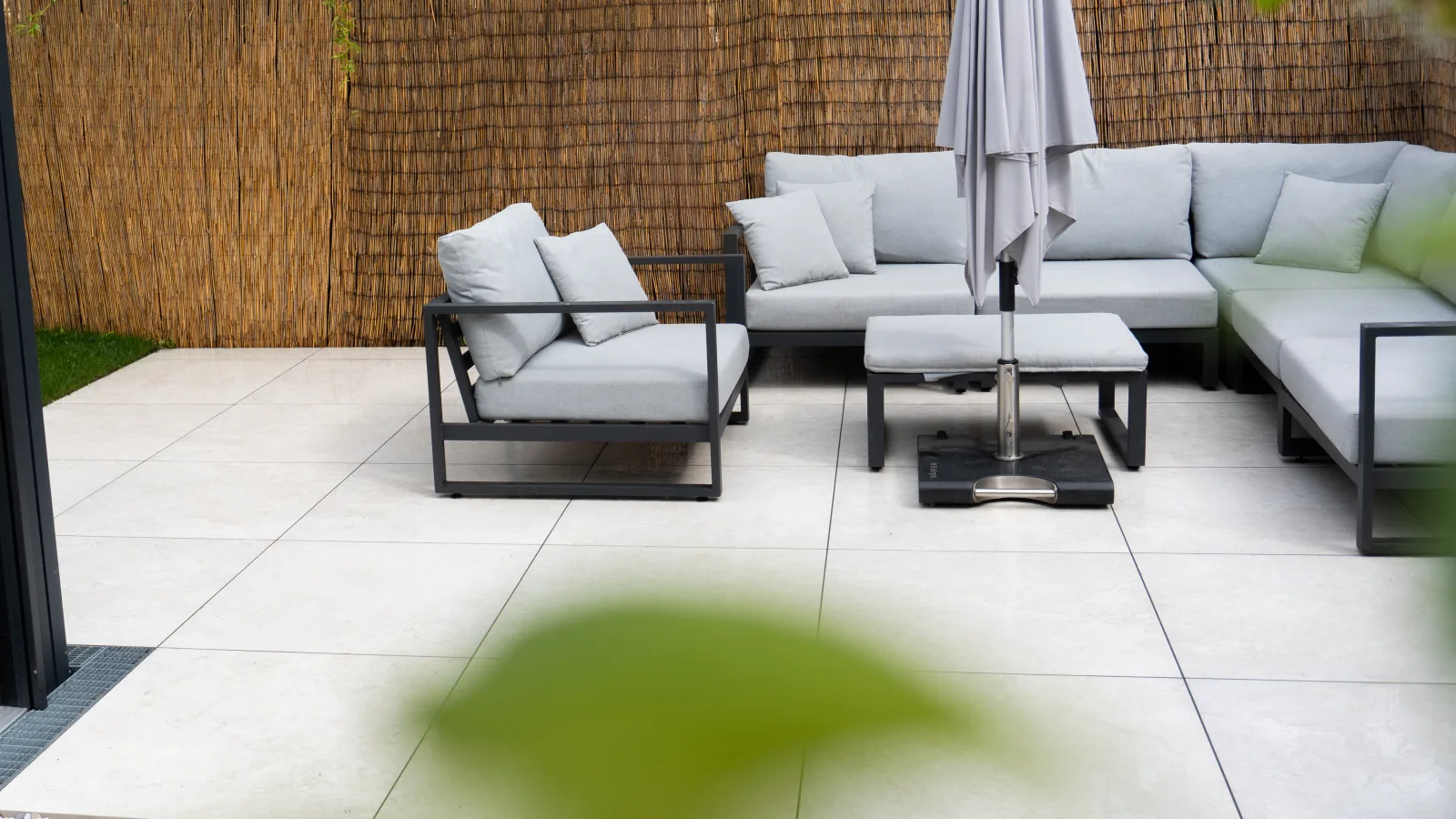 Terrasse mit Lounge, Sonnenschirm und Schilfzaun – Fliesenleger Erlangen Meisterbetrieb Jan Dimov